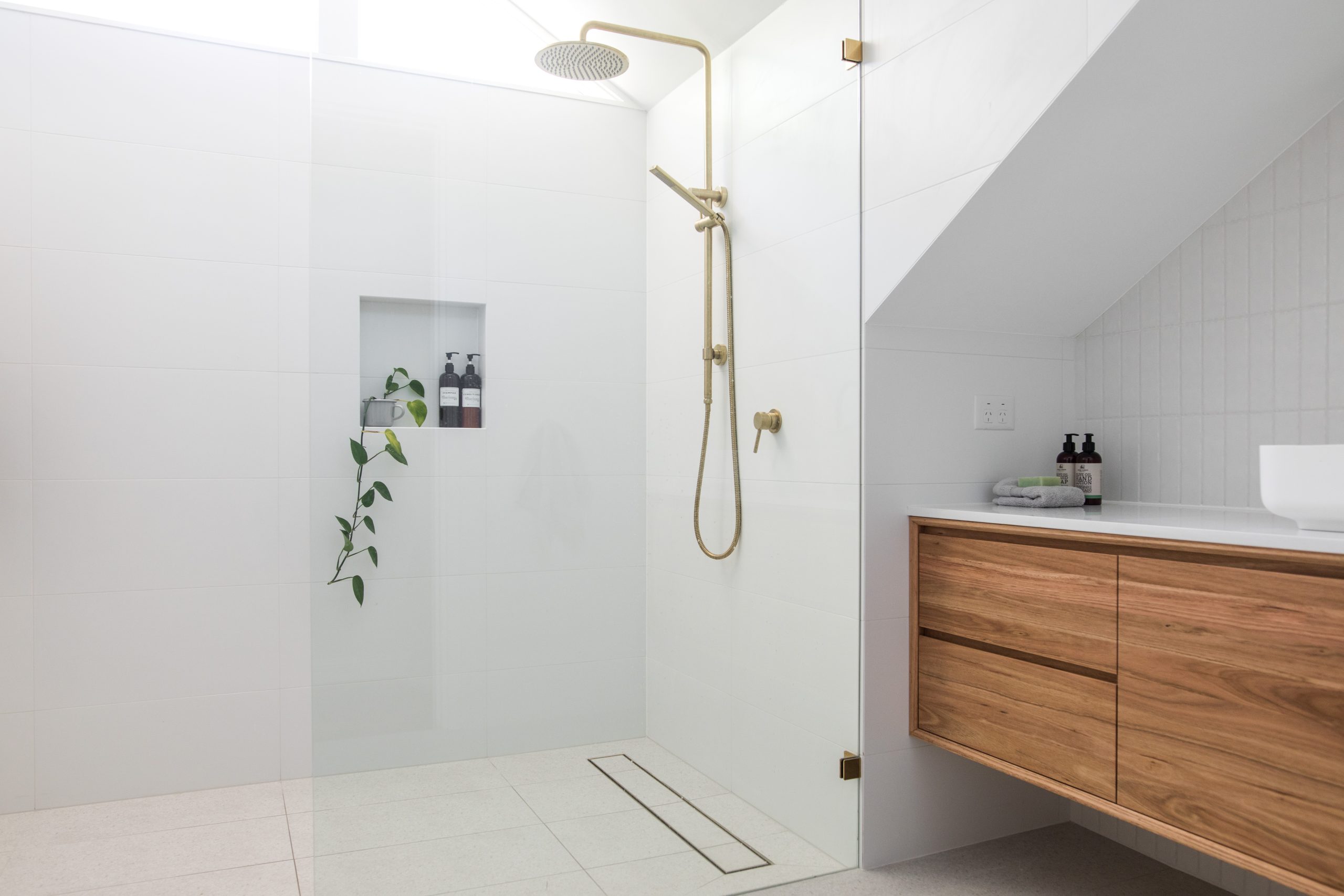 Barrier-free shower in a Niagara Falls home with handheld spray and bench for seated use.